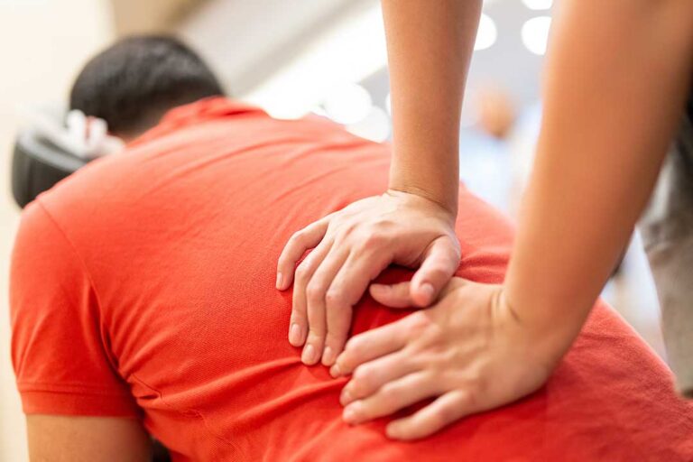 A person receiving a gentle spinal adjustment in a bright, comfortable clinic setting.
